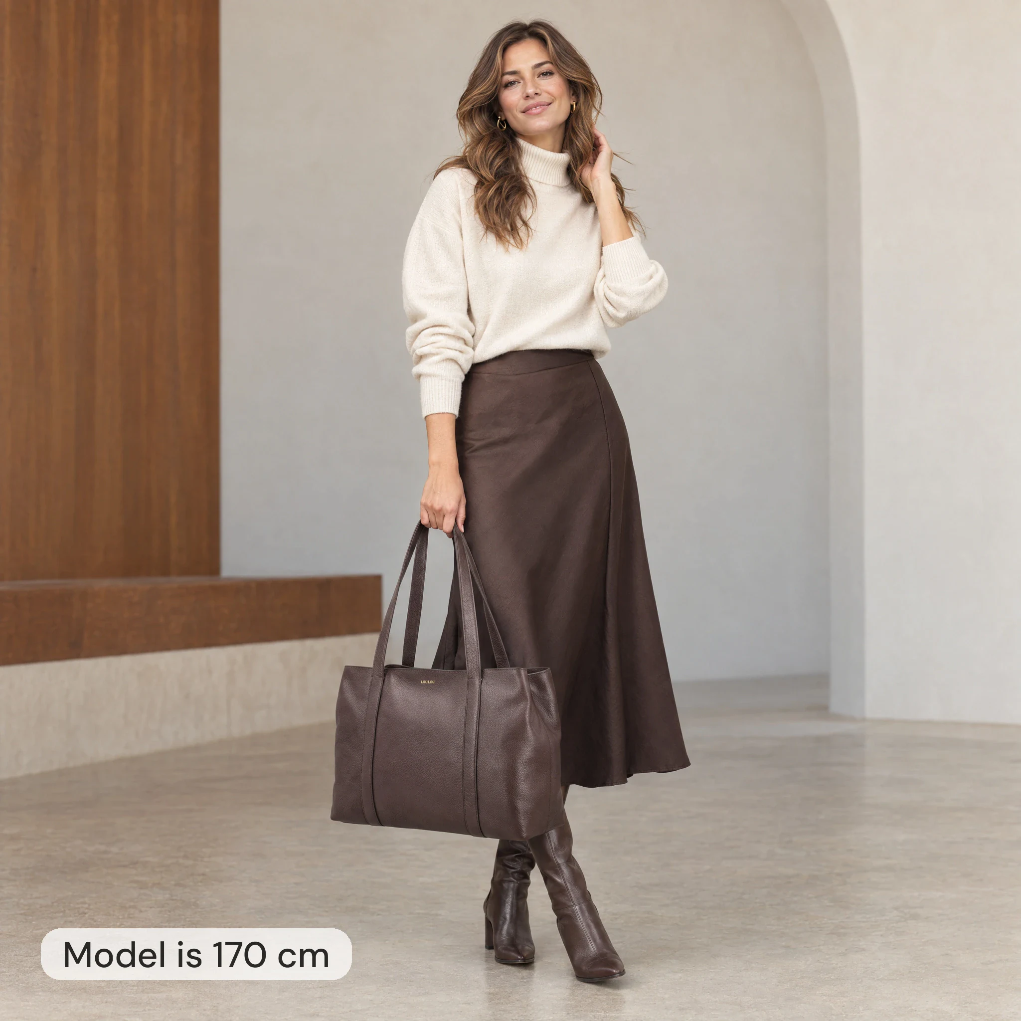 AI-modelbeeld: vrouw van 170 cm met een bruine Loulou-shopper van 50 cm breed in de hand