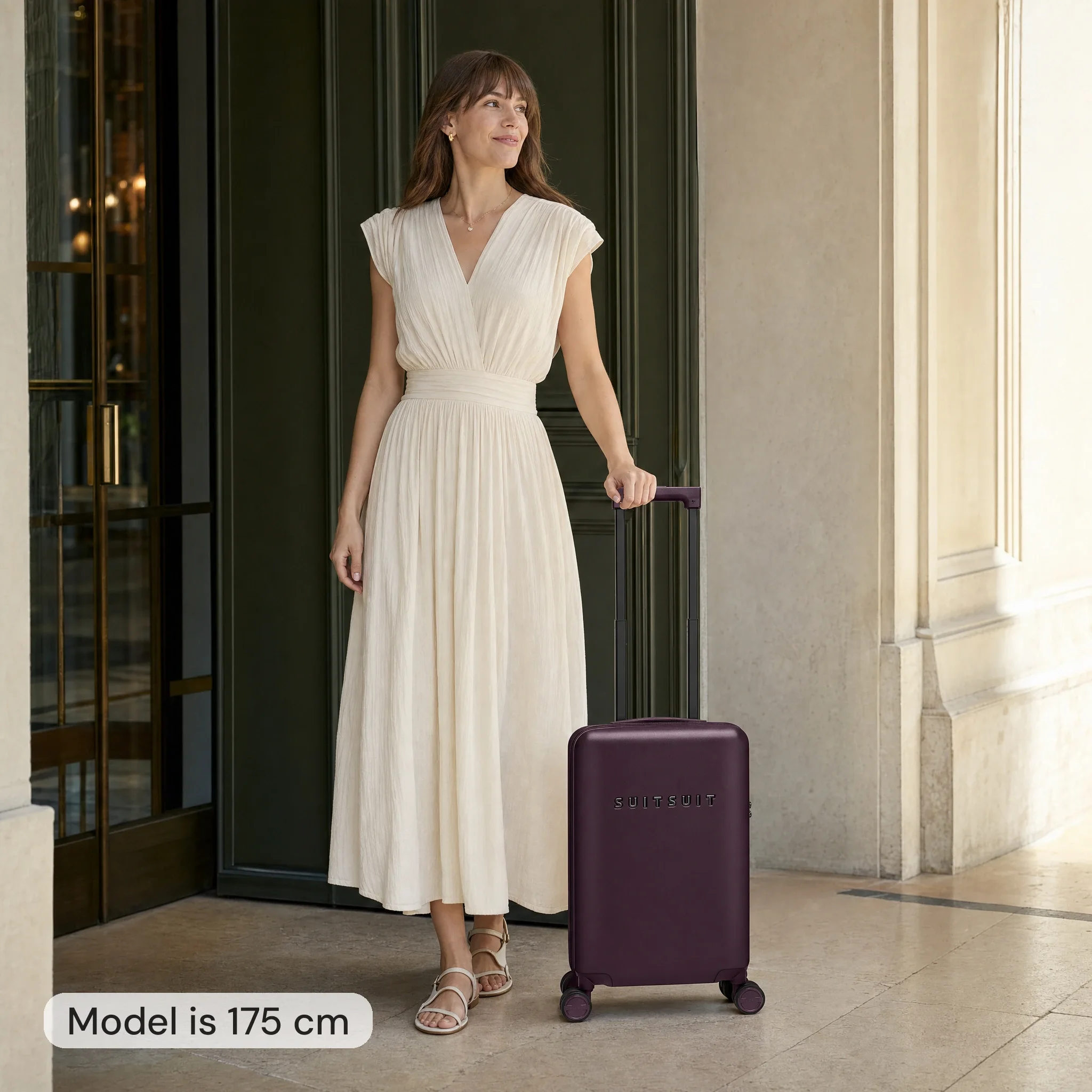 AI-modelbeeld: vrouw van 175 cm naast een bordeauxrode Suitsuit-handbagagekoffer van 54 cm hoog
