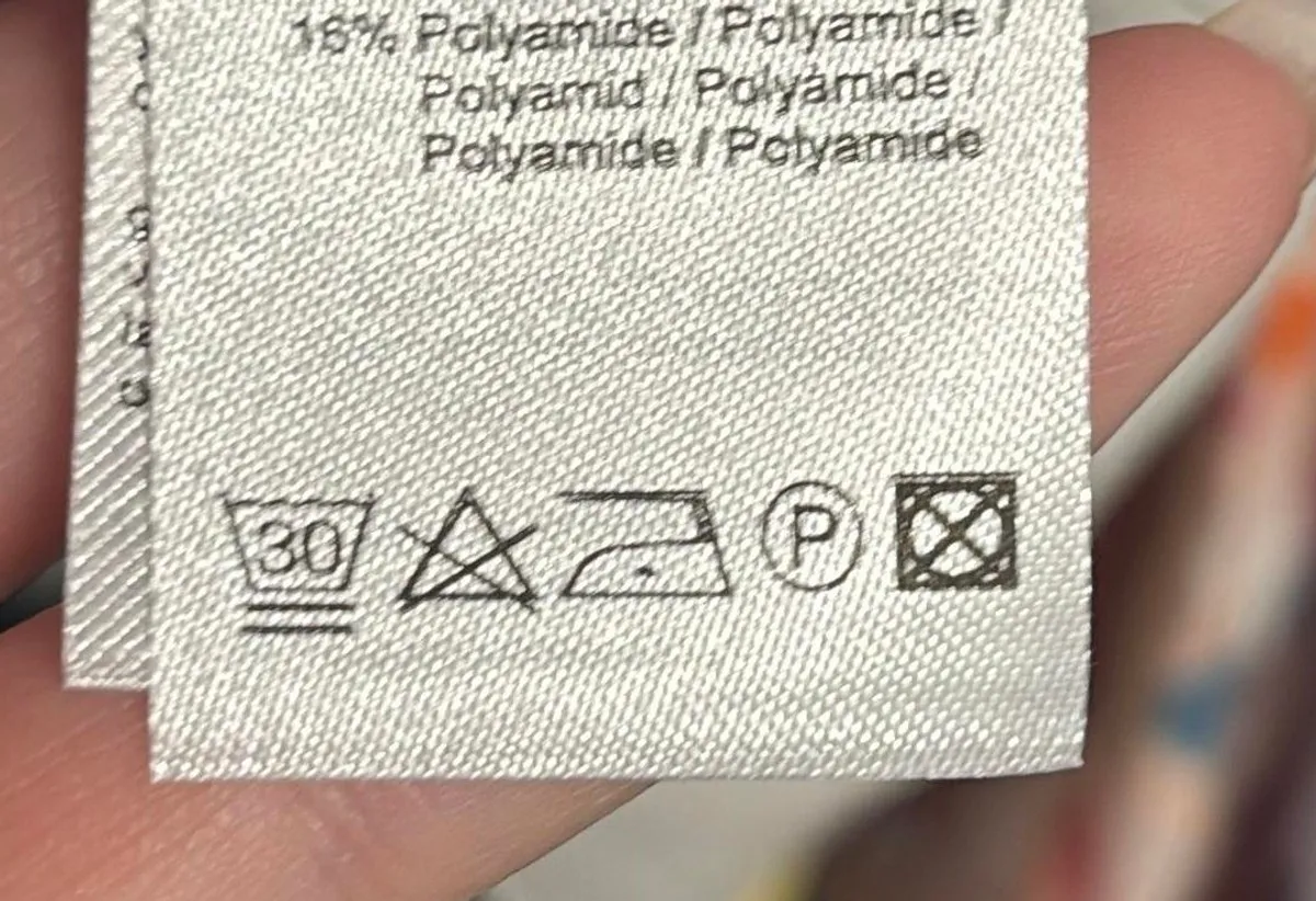 Foto van een waslabel met wassymbolen